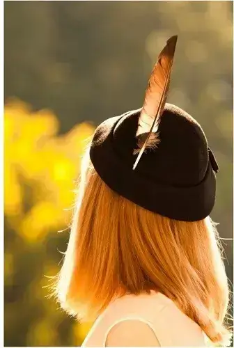 羽根つき帽子をかぶった女性